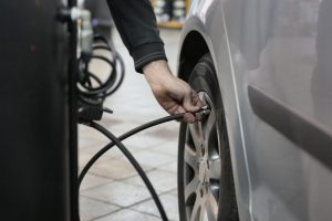 Person Adding Air to Car Tire